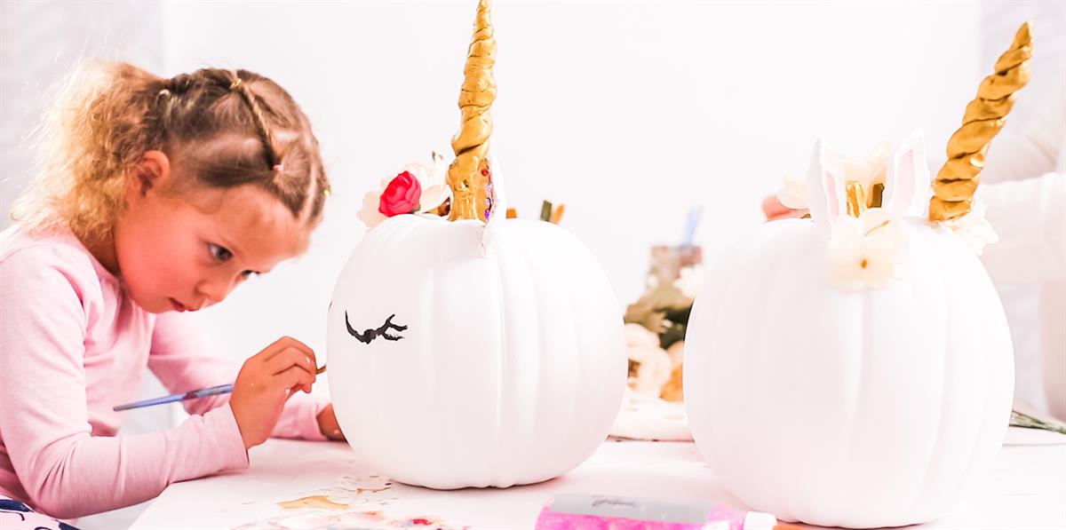 Girl painting pumpkin Girl painting a pumpkin like a unicorn.