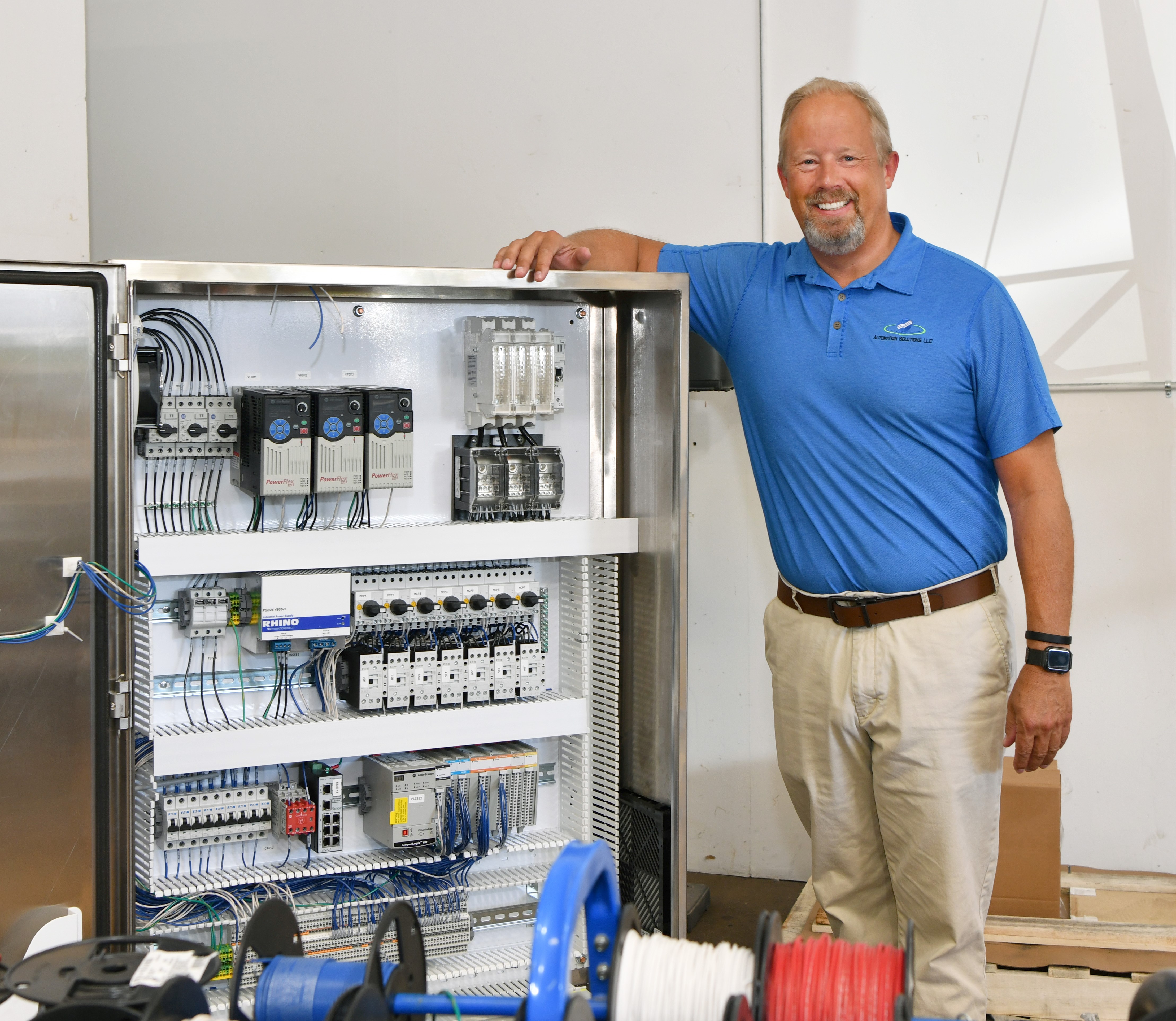 Automation Solutions president Steve Nordness stands next to control panel.